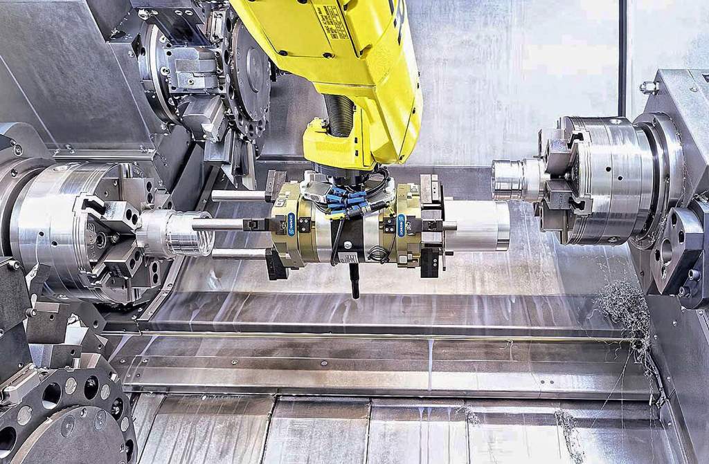 Machining area of a CTX beta 800 4A, showing the FANUC robot of the LoadAssistant deploying a double gripper for loading and unloading components